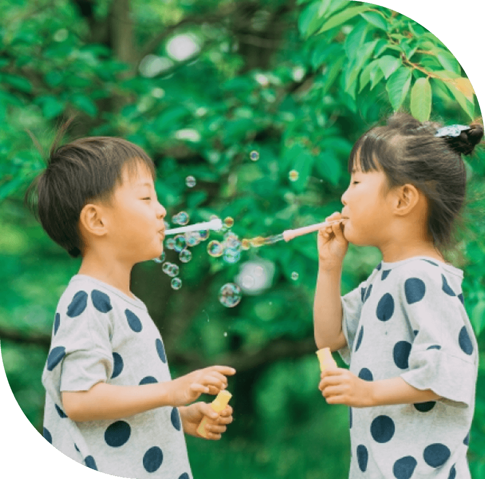 子供が向かい合ってシャボン玉をする写真